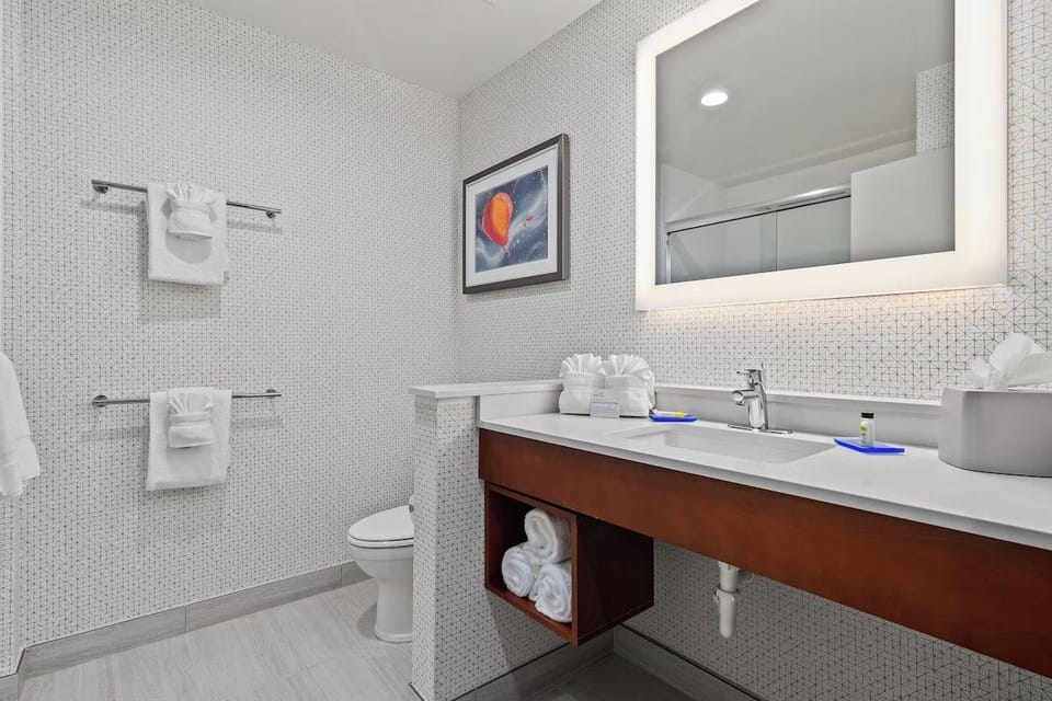 Refresh in a spotless bathroom with bright vanity lighting.