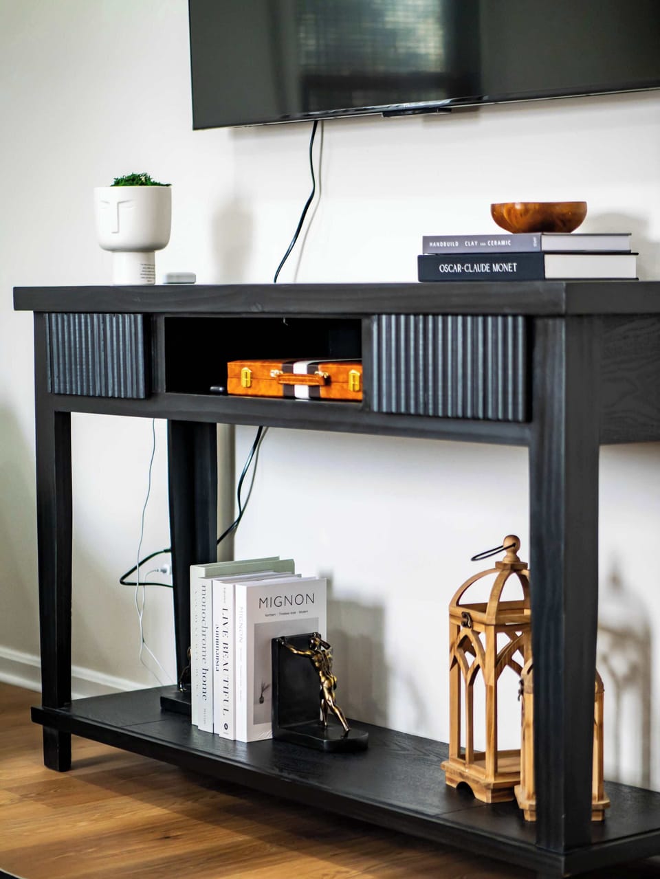 Console table beneath the TV w/ décor & storage for books, games & media