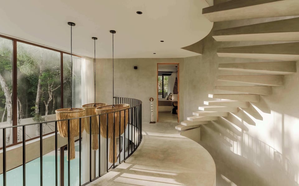 The curved staircase adds an architectural touch as it flows through the villa.