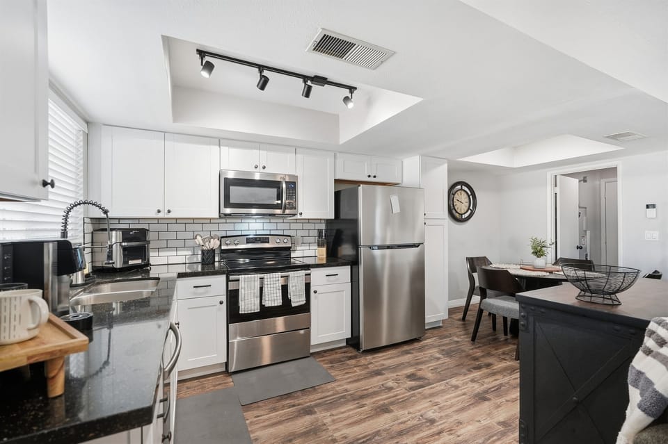 Bright, fully equipped kitchen with stainless appliances and inviting dining space.