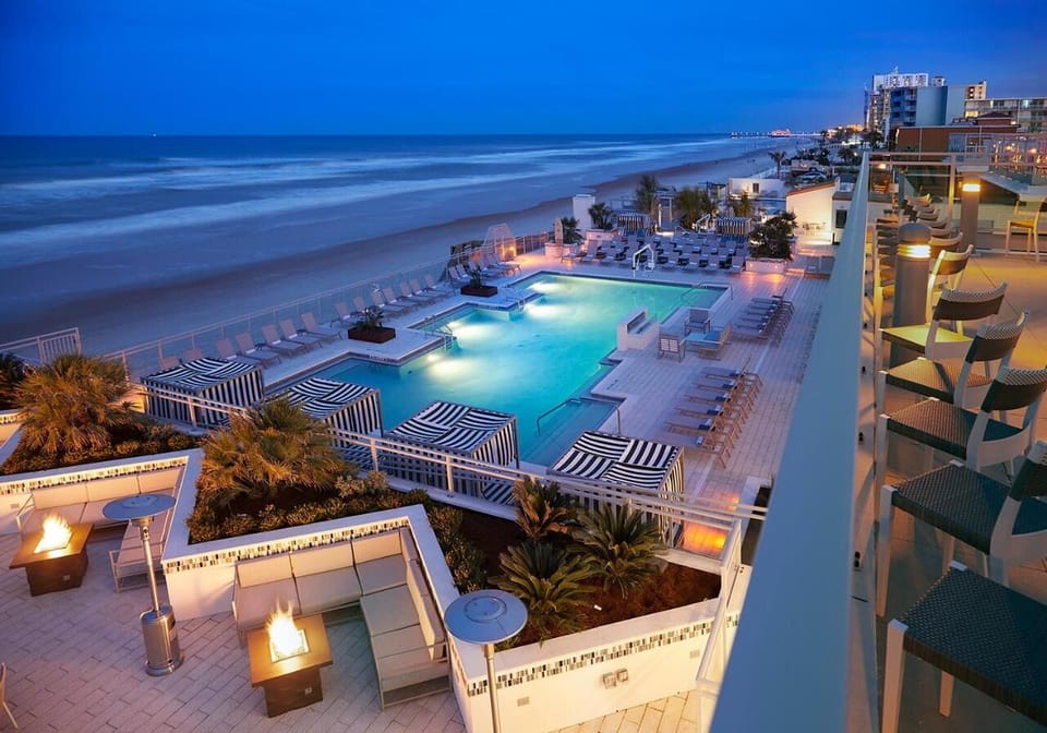 Toast the night above the waves with glowing pool views.