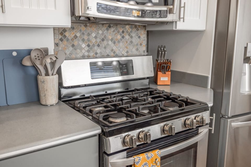 Fully equipped kitchen with gas stove, modern finishes, and cooking essentials.