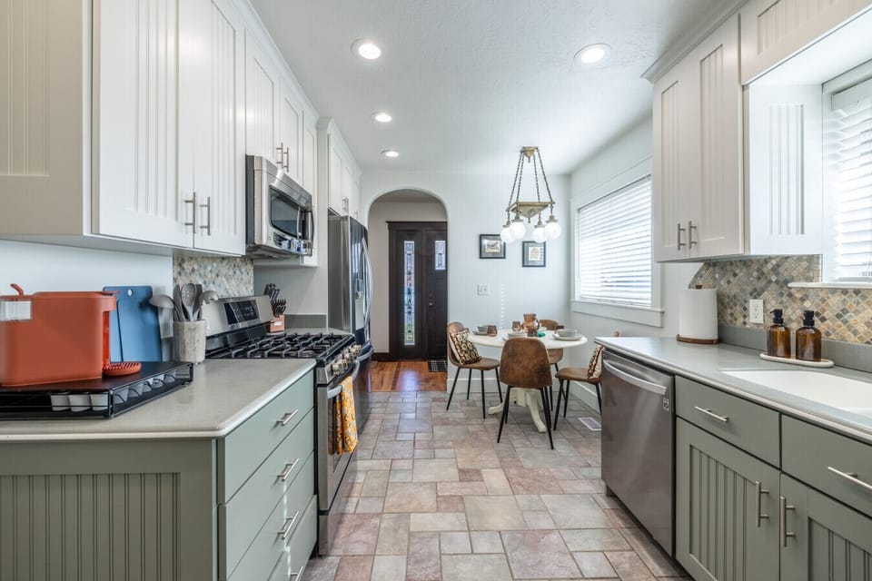 Bright, spacious kitchen with full appliances, ample counter space, and dining area nearby.