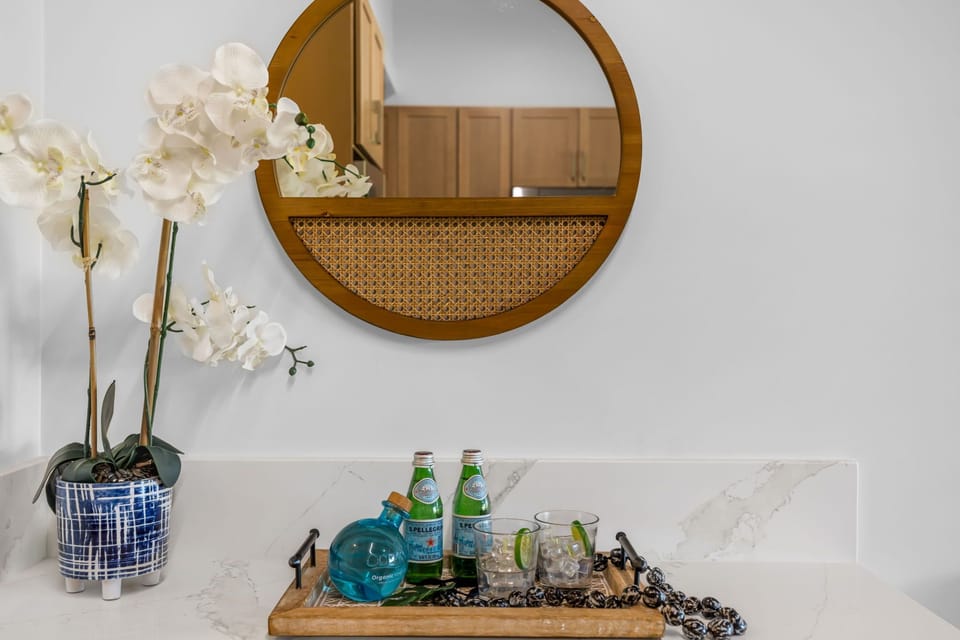 A refreshing welcome awaits you. This stylish console features a round rattan mirror and plenty of space to set down your keys and beach gear as you settle into vacation mode.