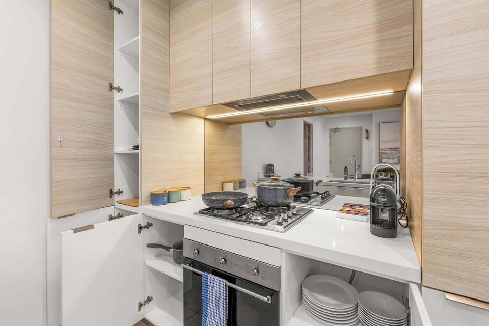 Fully equipped modern kitchen with gas cooktop, oven, quality cookware and dinnerware, plus a complimentary Lavazza coffee machine with capsules.