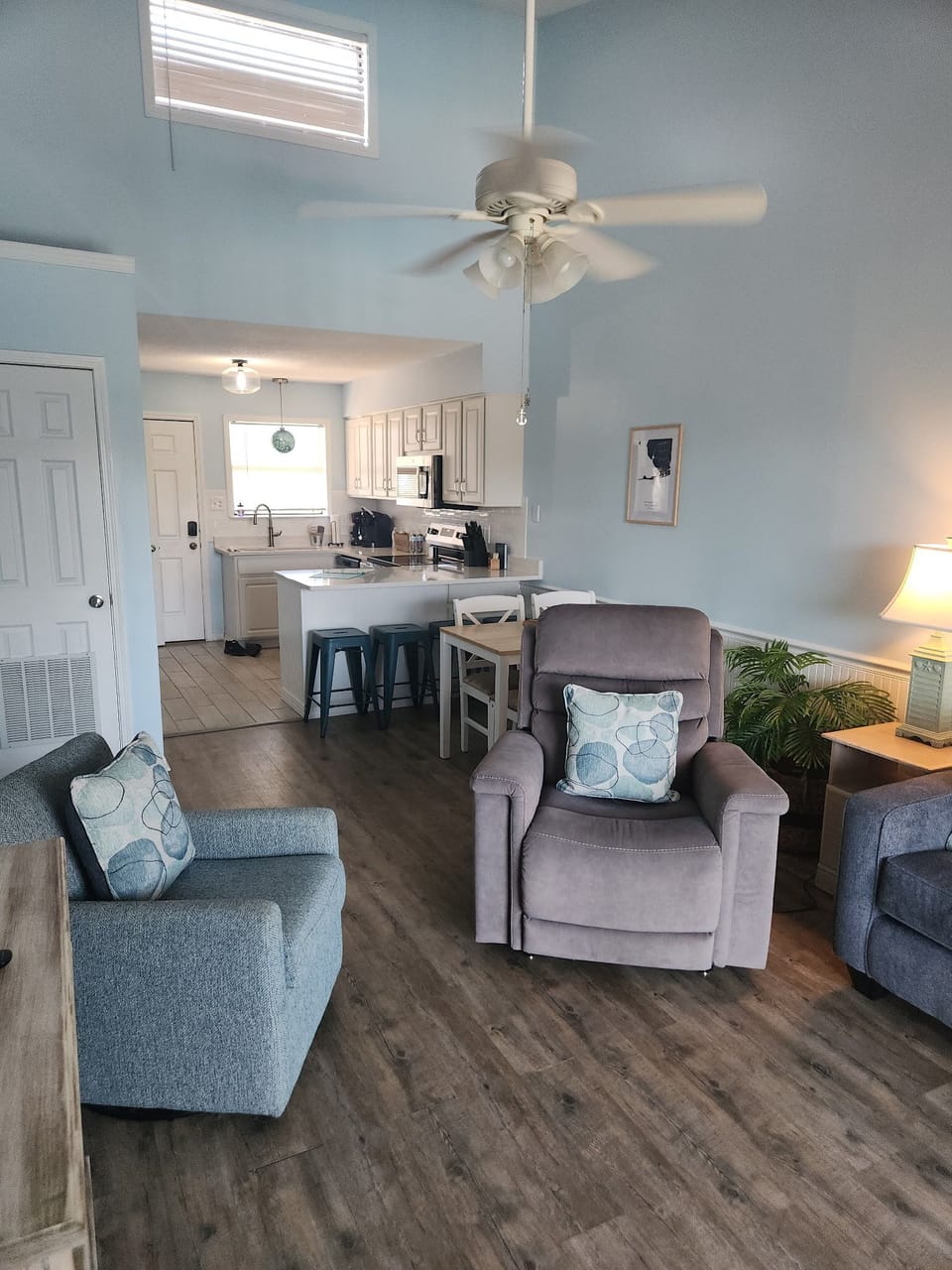 Bright open living space with vaulted ceilings, cozy seating, and kitchen bar