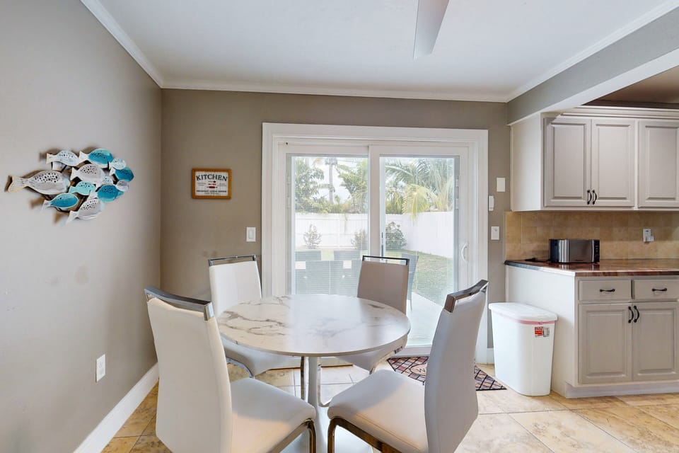 Comfortable dining area, seats for four, with ceiling fan.