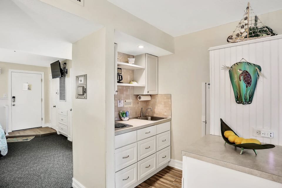 The kitchen has a two burner stove, sink, coffee maker, fridge, and microwave.