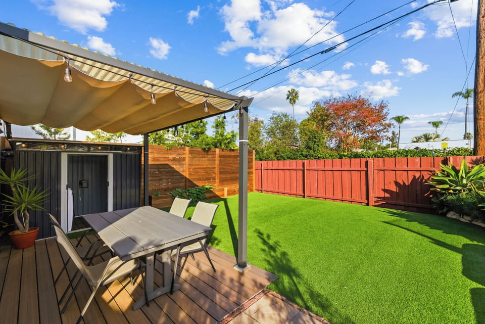 Large green backyard with seating and plenty of space for your and your pets to enjoy. Outdoor dining, fresh air and convenience of an outdoor washer & dryer.
