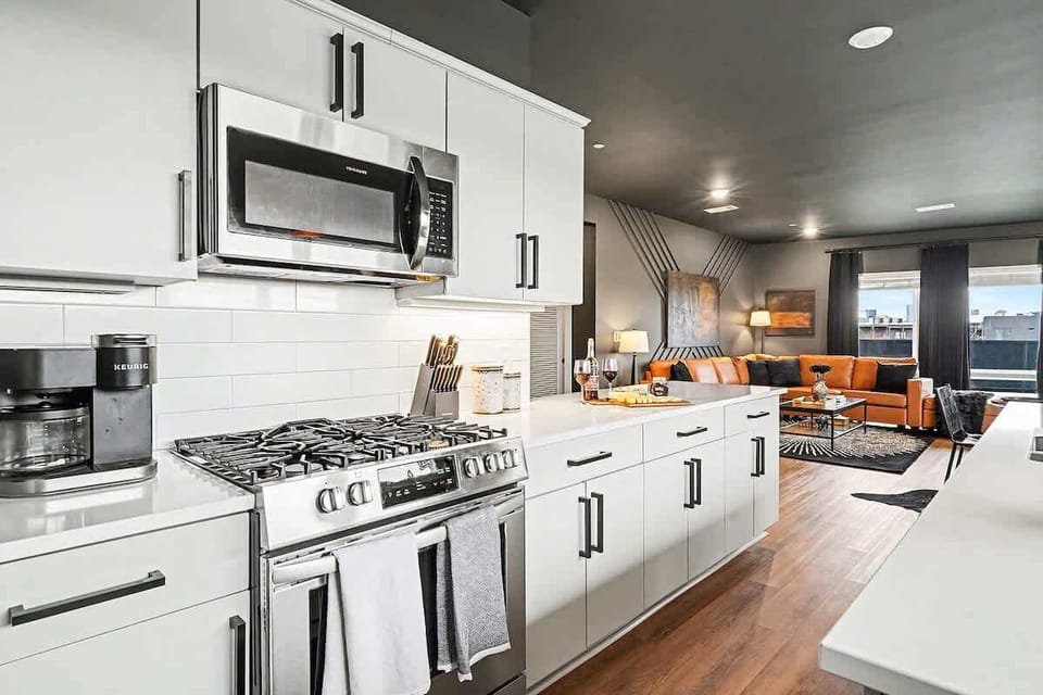 Fully equipped kitchen, complete with stainless-steel appliances and a kitchen island with ample counter space and bar seating.
