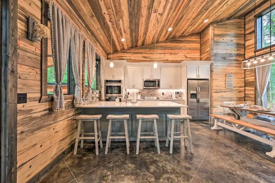 Bright, stocked kitchen with modern appliances and island seating for a group.