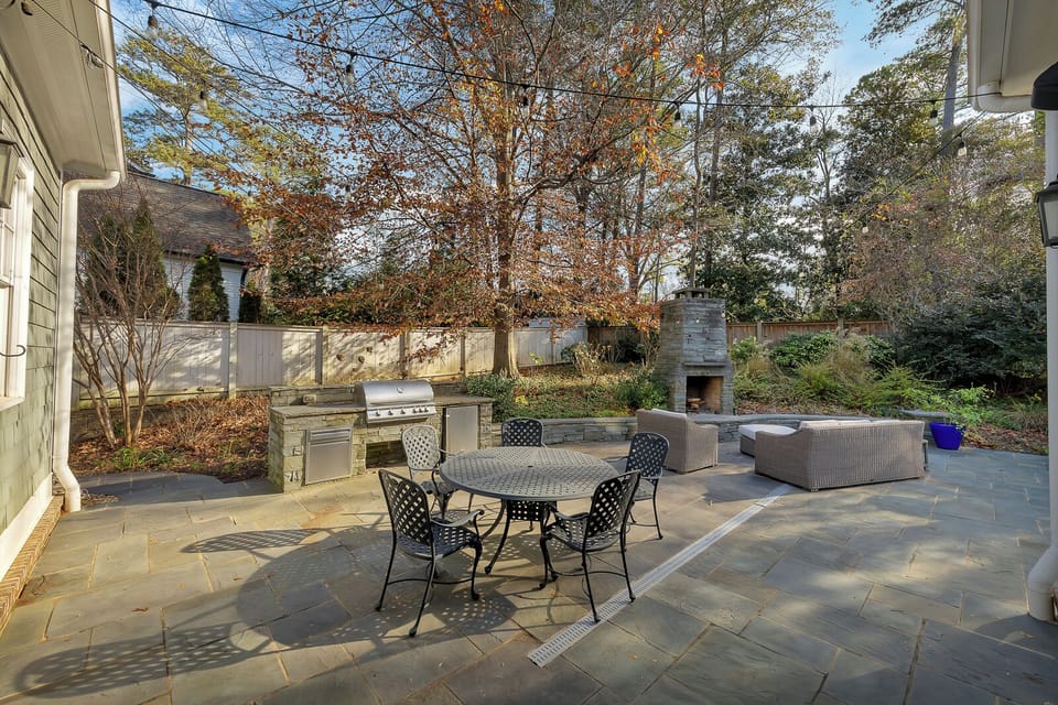 Outdoor dining area w/ grill & umbrella seating, perfect for al fresco meals