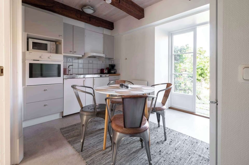 The cozy, bright, & well-equipped kitchen with a dining table.