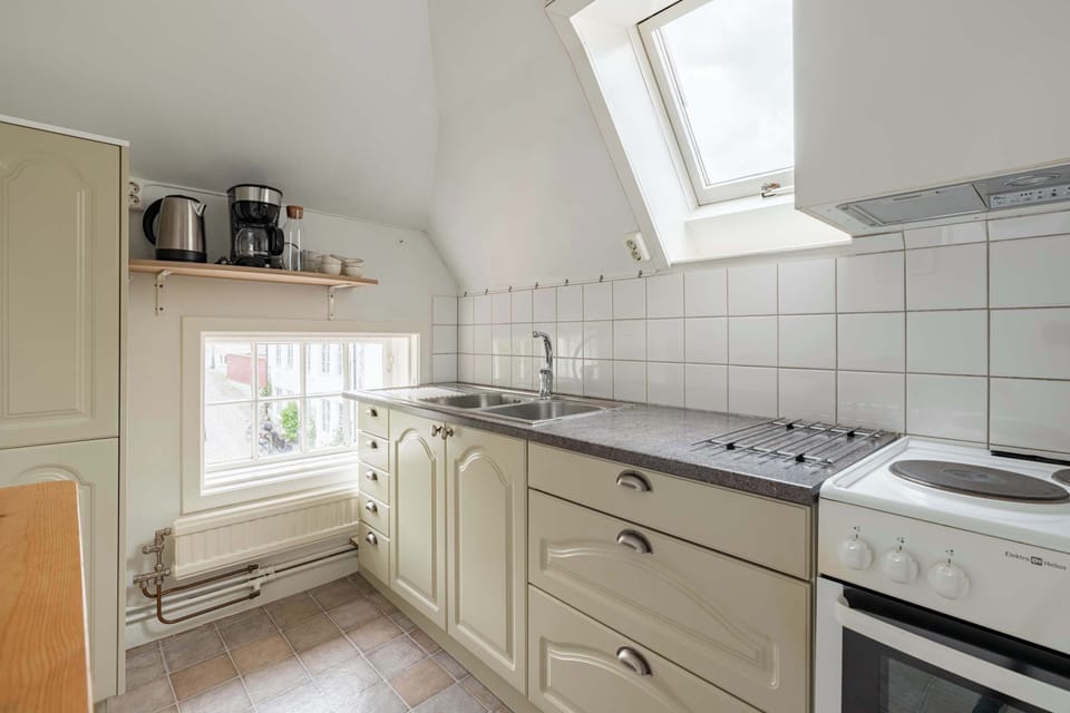 Fully equipped kitchen with all essentials you will need for a home cooked meal. There is a stove, oven, fridge, freezer, coffee maker and water boiler, toaster and essentials. A small seating area in the kitchen for two guests.