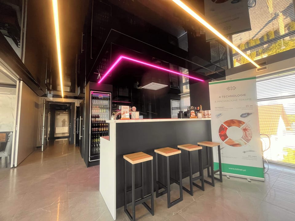 A stylish bar area with illuminated accents, modern counters, and seating space.