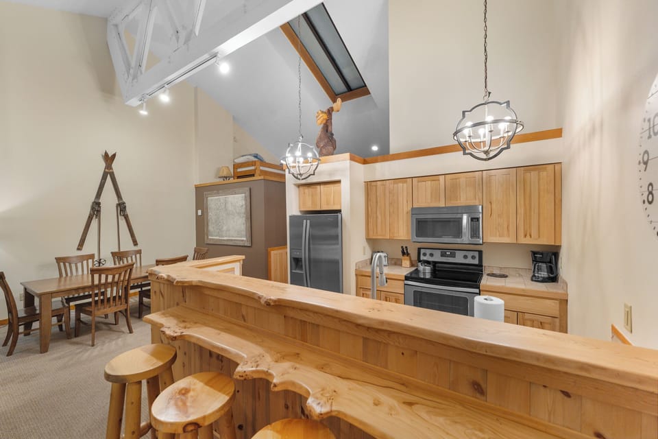 Full kitchen with stainless steel appliances and breakfast bar.