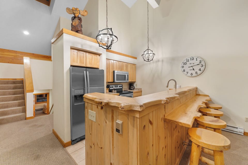 Full kitchen with stainless steel appliances and breakfast bar.