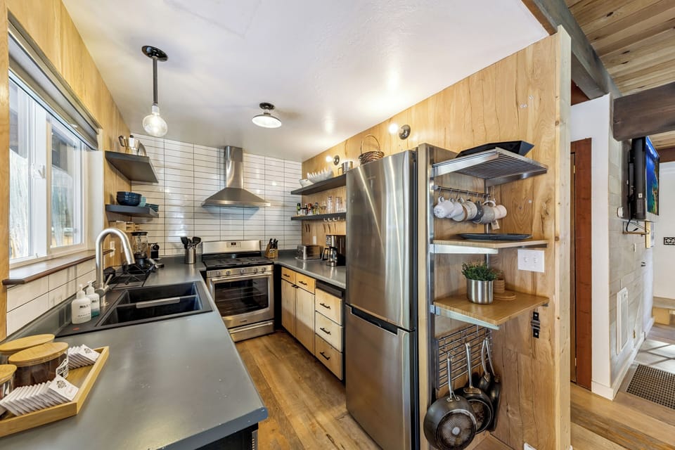Fully equipped kitchen with modern appliances, open shelving, and thoughtful design for easy meal prep.