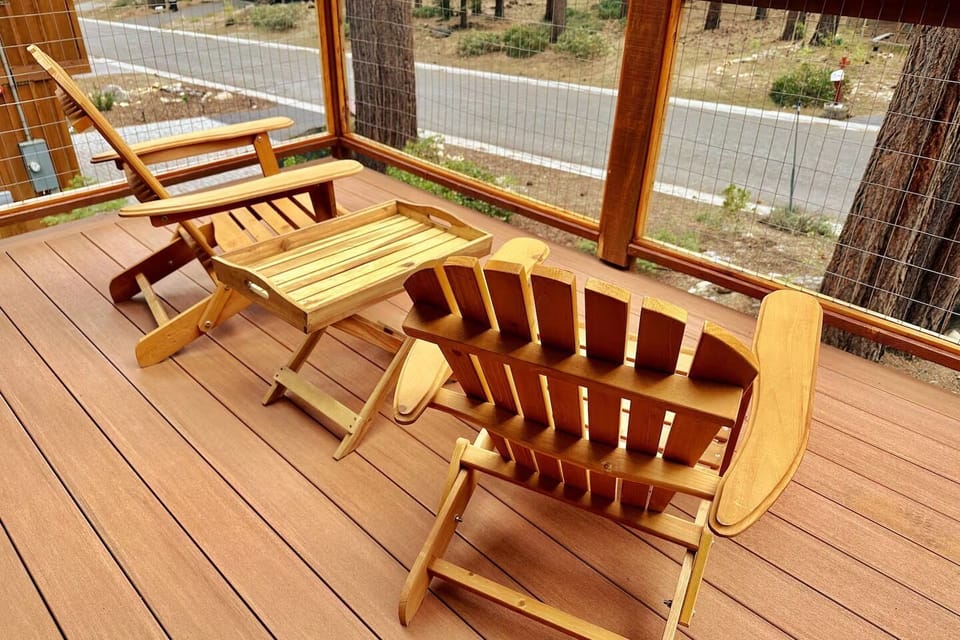 Relax on your private deck with handcrafted wooden furniture and peaceful garden views beyond the screened enclosure.