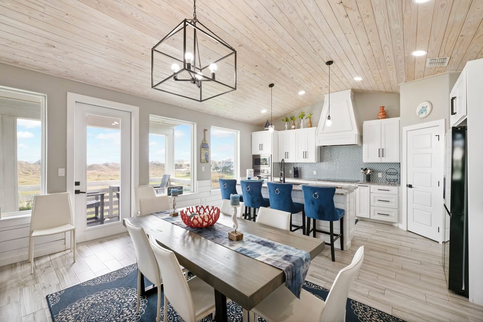 Gather around this stunning open kitchen and dining space where rustic wood meets modern elegance, perfect for creating memories together.
