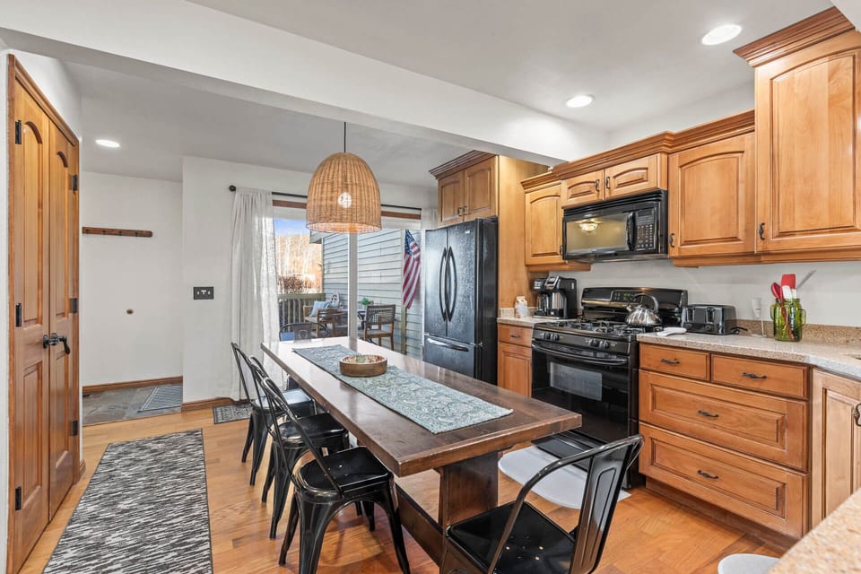 Step into your fully equipped kitchen featuring warm wood cabinetry, modern appliances, and a welcoming island where you'll gather for memorable meals.