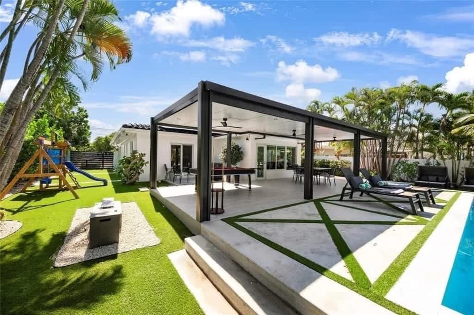 Dine, dip, and play in this family-friendly tropical oasis—featuring a sleek pergola patio, modern pool, and kids’ playset. Ideal for vacation rental guests seeking style, comfort, and fun for all ages. Your outdoor escape is ready to impress!
