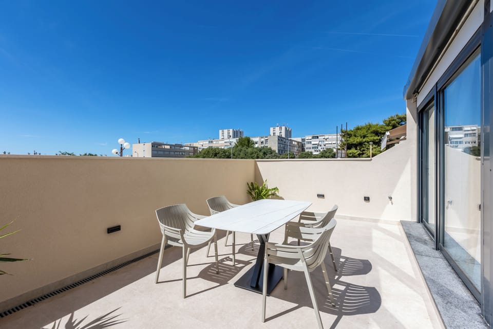 Balcony with views of nature and nearby buildings, calm urban setting.
