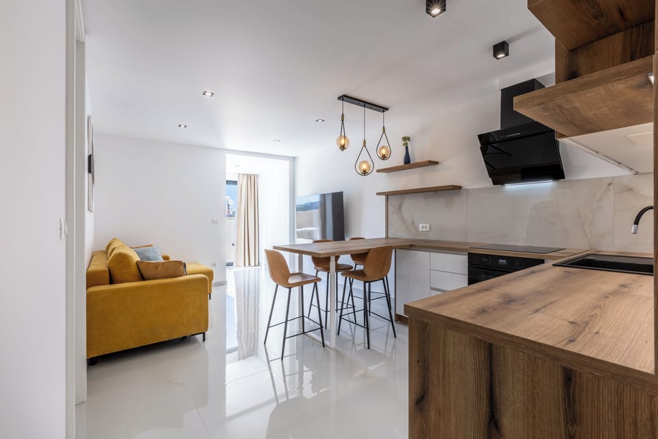 View of the living room and kitchen with an open-plan, modern layout.
