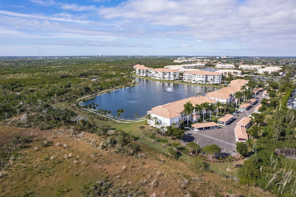 Aerial view of building, lake and landscaping.