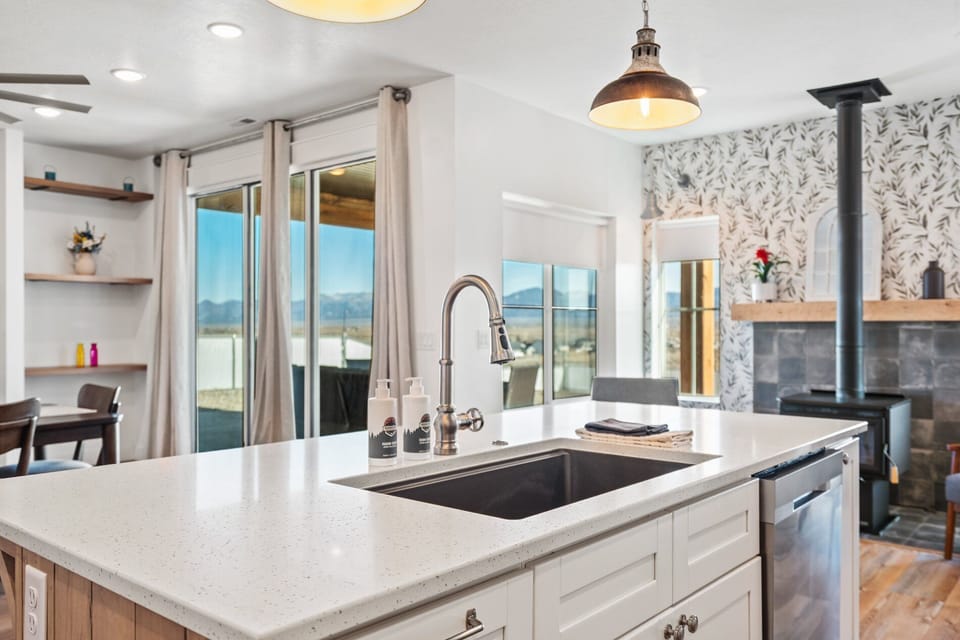 Kitchen island with prep sink, pendant lighting, and panoramic views of the valley and mountains.