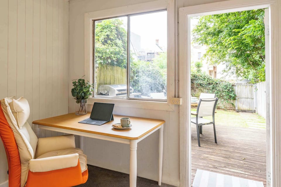 Second living space with 2 desks, ergonomic chairs and sofa leading to the back yard. 