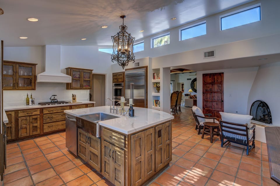 A large gourmet kitchen includes a five-burner gas stove and a cooking island.