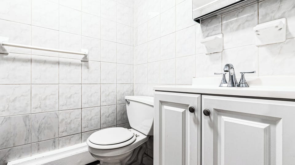 Fresh white marble tiles and elegant fixtures create your perfect private retreat, complete with plush towels ready for relaxation.