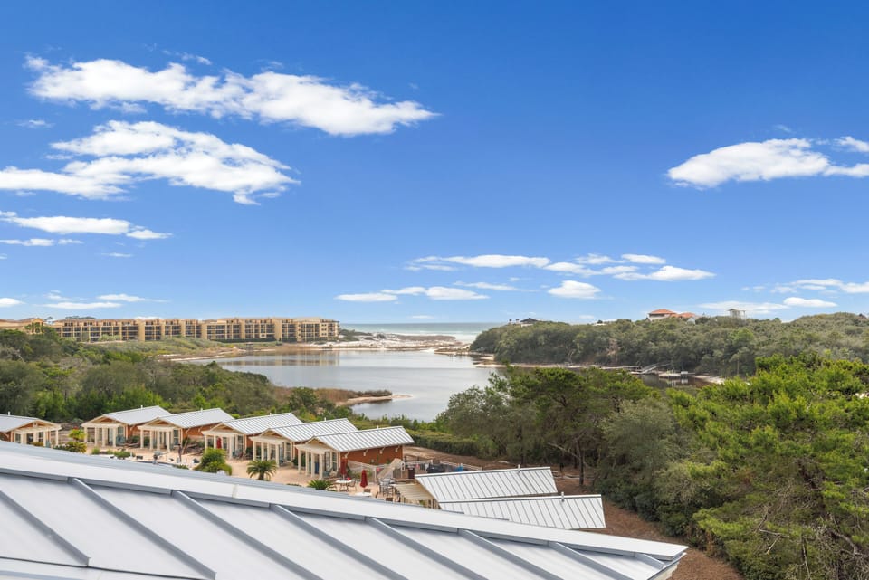 Elevated coastal view showcasing the serene waterway, lush vegetation, and nearby resort accommodations under expansive blue skies.