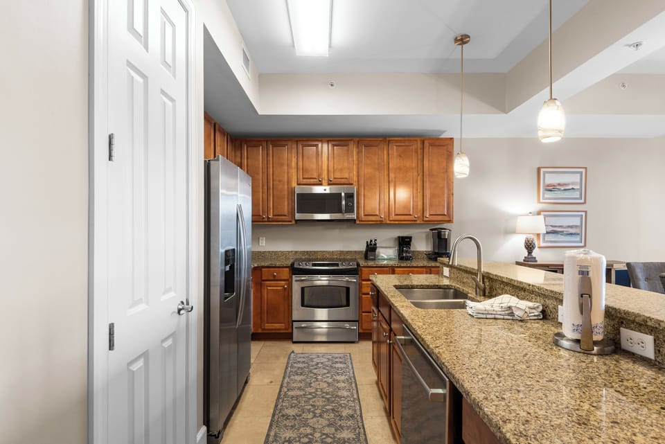 This fully equipped kitchen features granite countertops, stainless steel appliances, and warm wood cabinets for memorable meals.