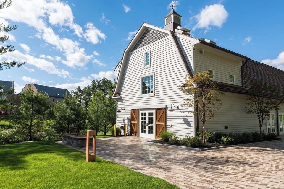 Arrive to a charming barn-style venue framed by green lawns.