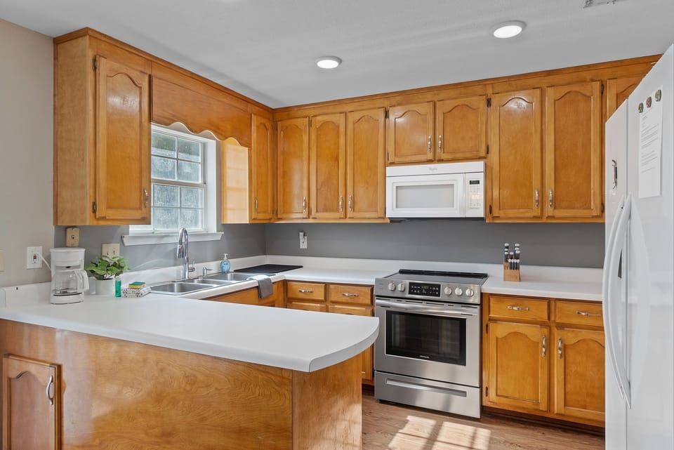 Spacious and fully equipped kitchen featuring modern appliances and classic wood cabinetry.