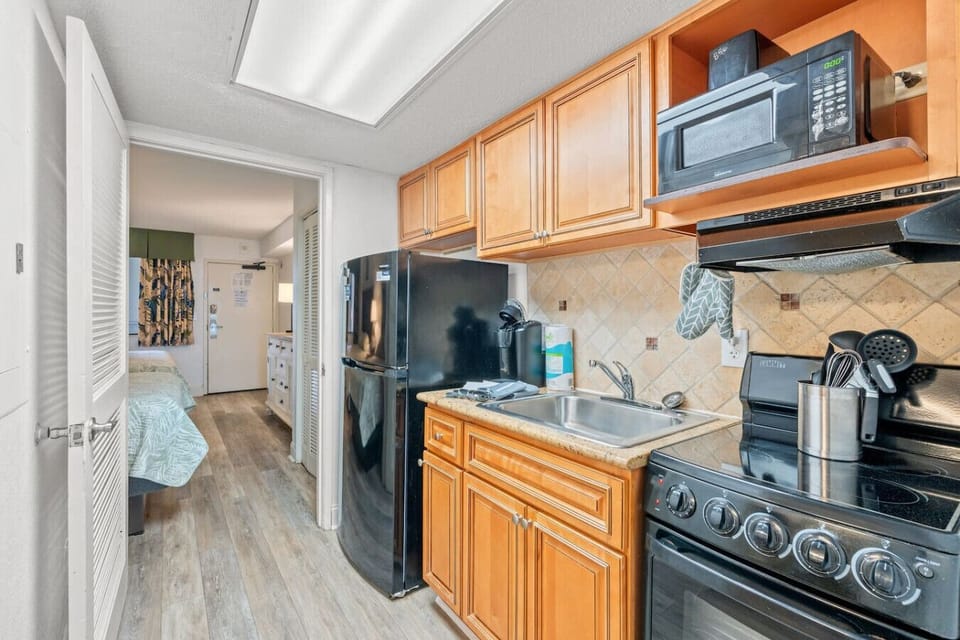 Fully stocked kitchen with full-size stove, oven, refrigerator, sink, Keurig maker, toaster, ample cabinets, plus dinnerware, cookware, and silverware—everything needed for easy, convenient vacation meals.