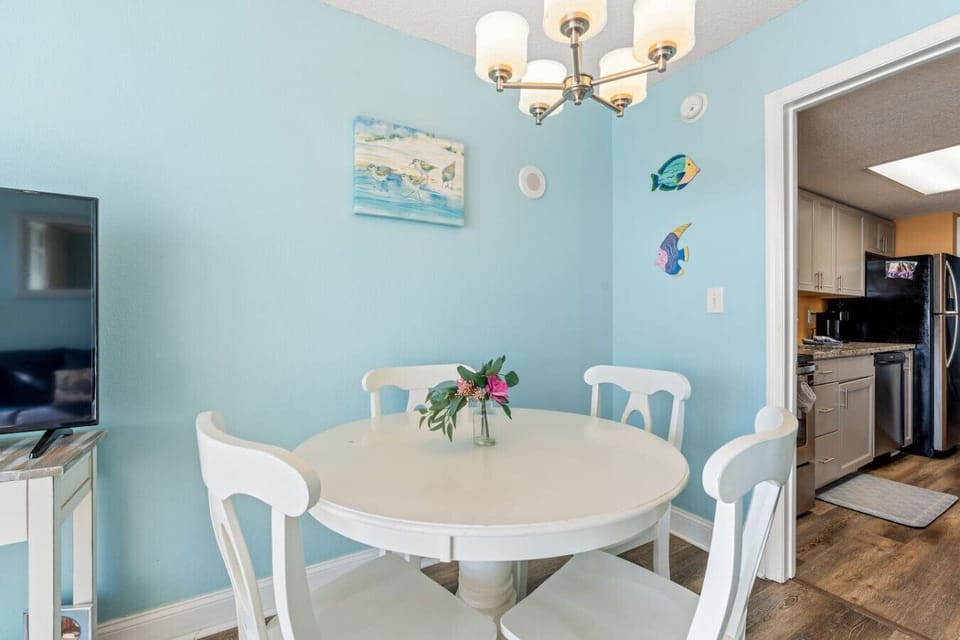 Oceanfront dining area seating four comfortably, perfect for family meals or game night. Enjoy stunning coastal views while dining in this charming Myrtle Beach condo filled with thoughtful extras for a relaxing vacation.