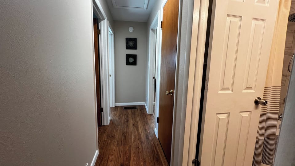Hallway connecting three bedrooms to the upstairs full bathroom.