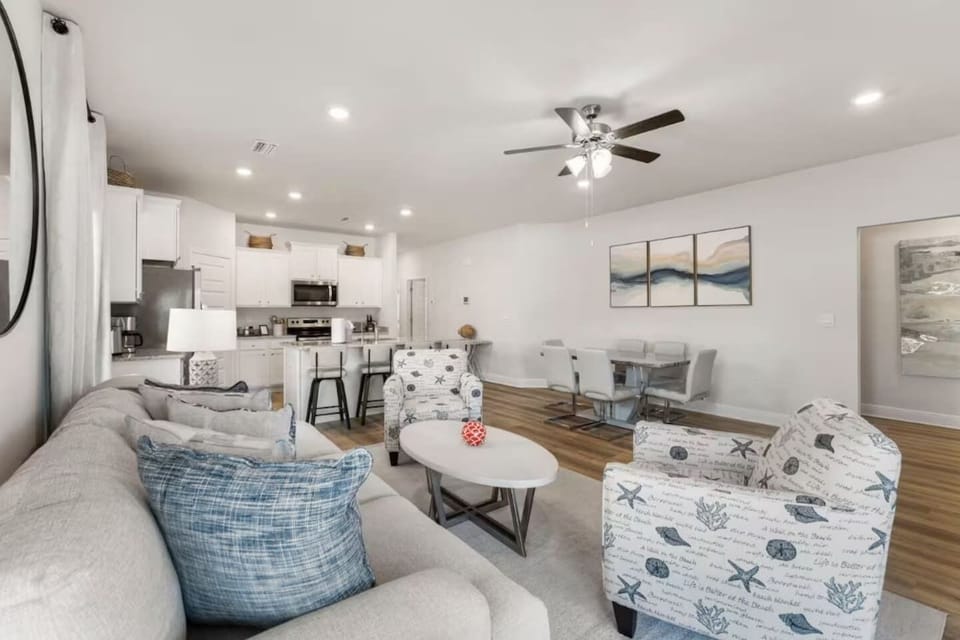 Main living: Kick back on plush couches and enjoy effortless indoor flow to the dining area and full kitchen.