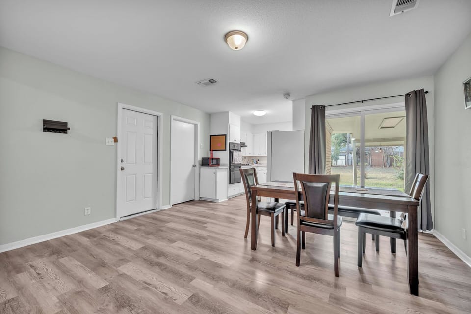 Dining area looking at a large, fenced backyard. 