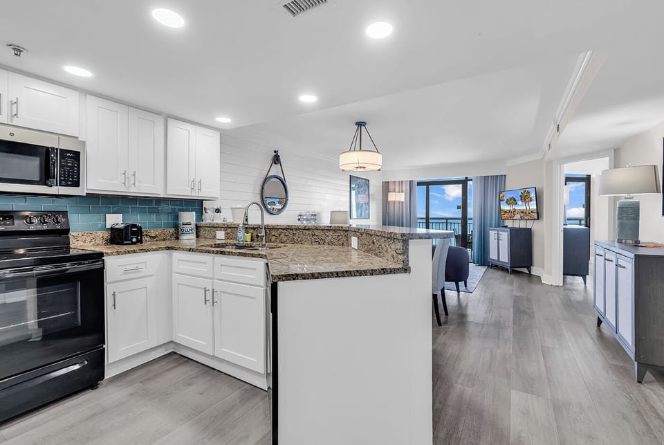 Kitchen with stove, fridge, dishwasher, microwave, coffee maker, toaster etc