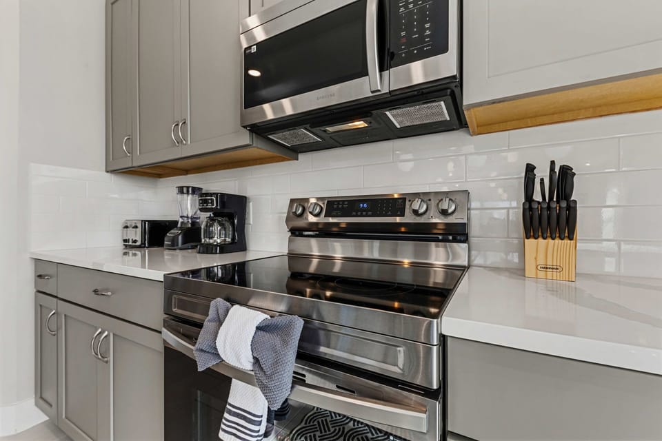 Cook with confidence: stainless range and microwave, coffee maker, blender, toaster, and full knife set-this stylish kitchen has all the essentials.