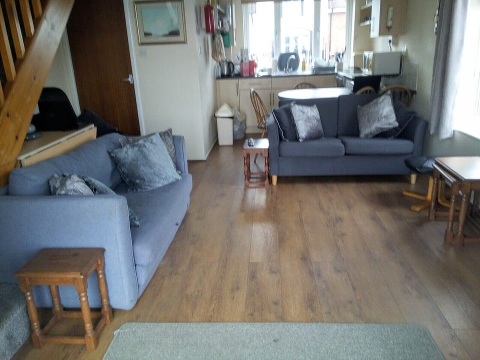 Living room with 2x2-seat sofas, leather arm chair, foot stool and casual tables