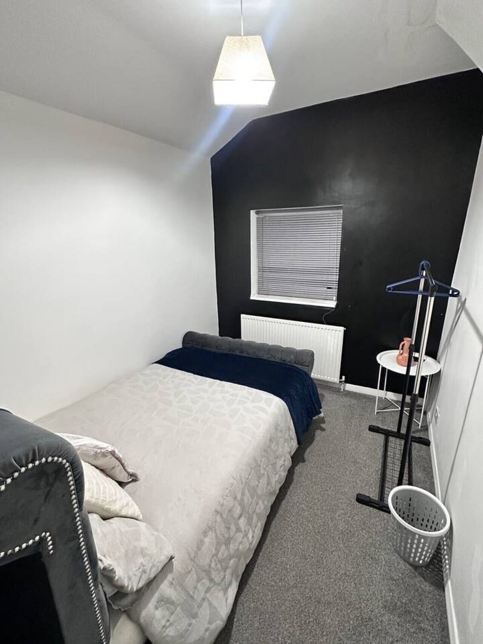 Light-filled bedroom with simple layout and clothing rail