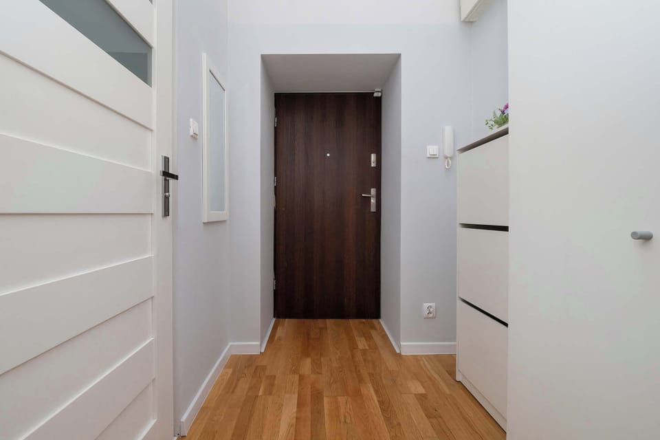The bright hallway with wooden flooring guides you through the apartment, offering easy movement and a well-organized first impression.