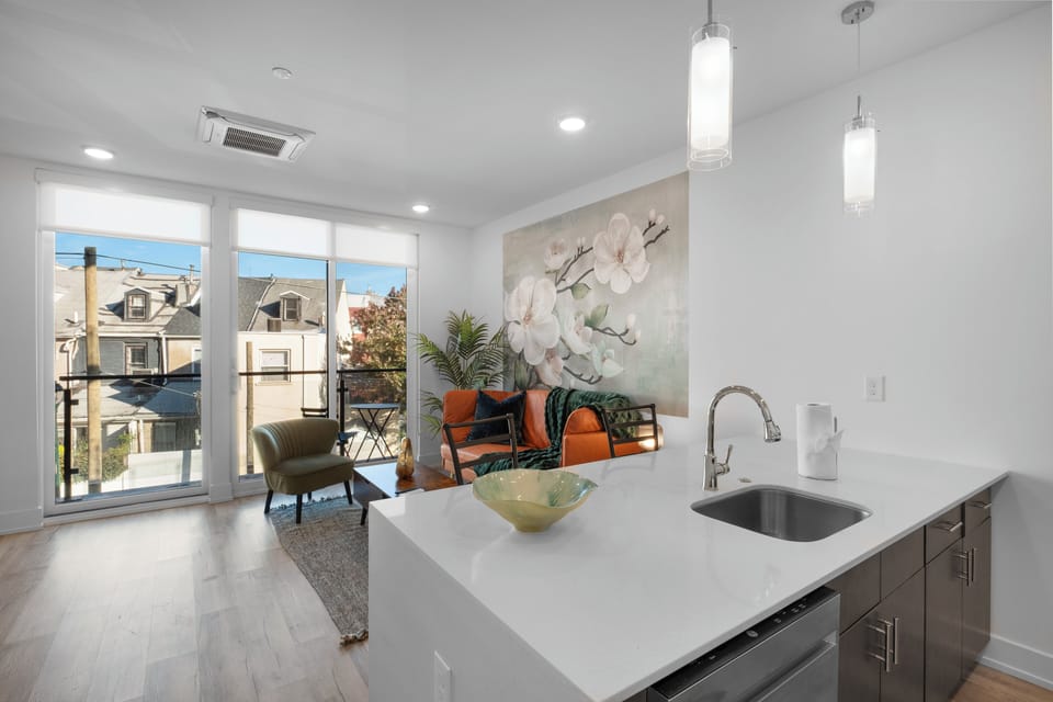 Open-concept kitchen and living area with wood cabinets, stainless appliances, and city views ideal for entertaining.