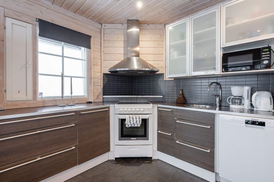 The kitchen is equipped with modern appliances and stylish dark surfaces
