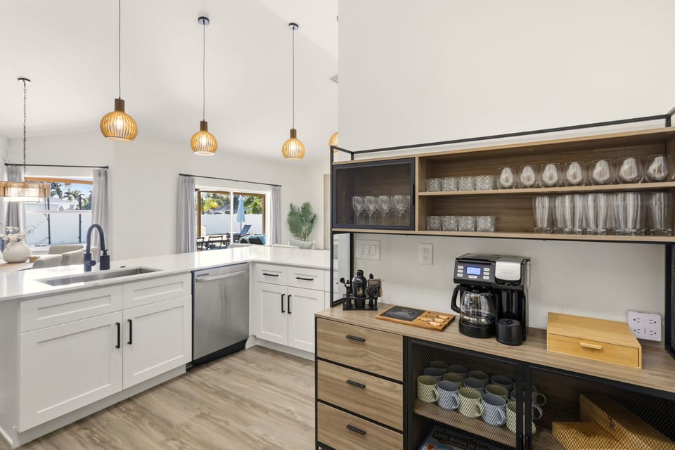 Coffee bar with drip machine, espresso maker, and stocked shelves